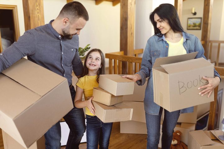medium-shot-parents-kid-with-boxes